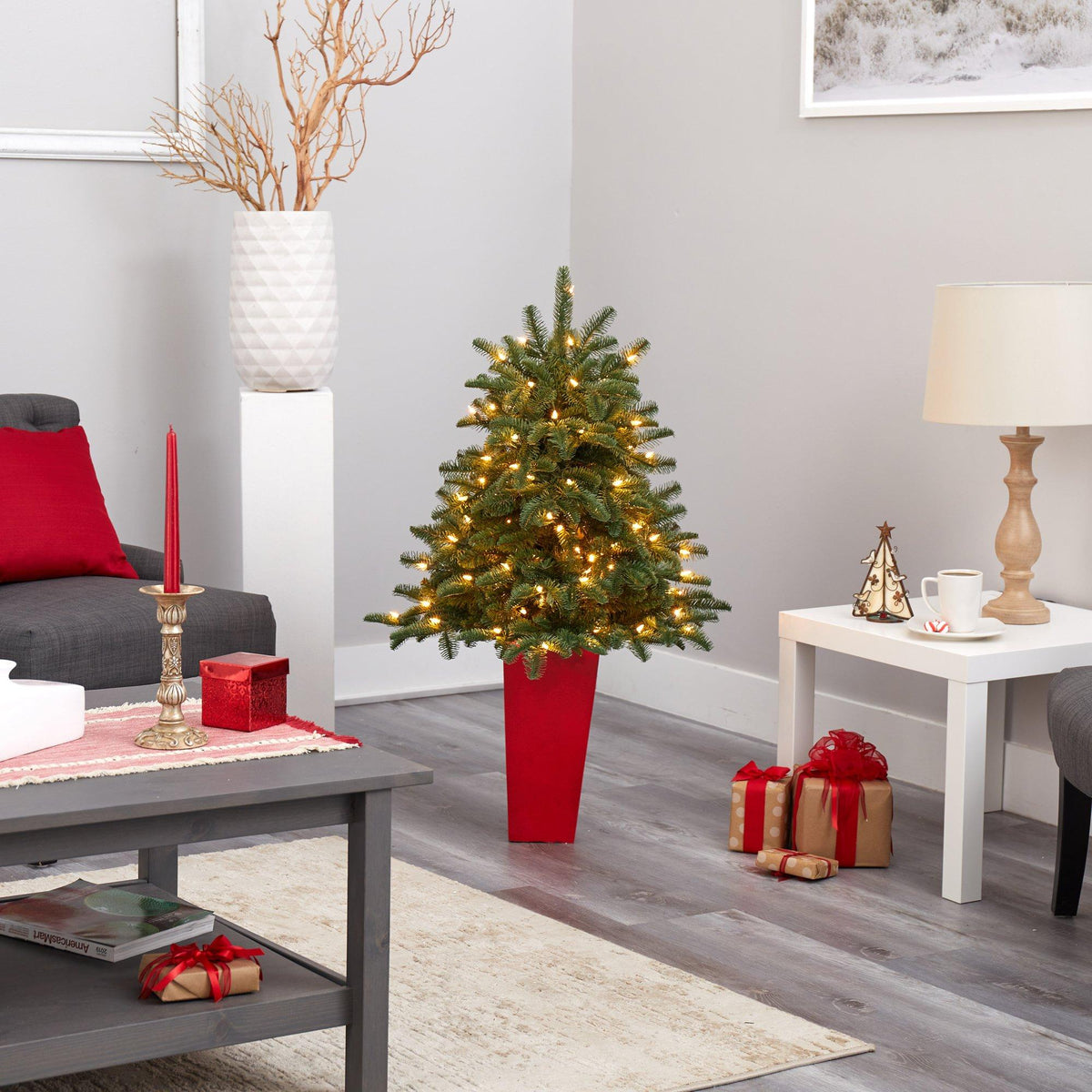 a christmas tree in a red pot in a living room