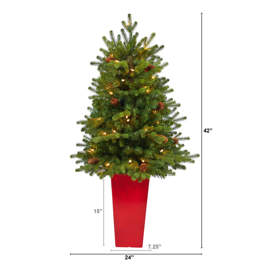 a tall christmas tree with lights and a red pot
