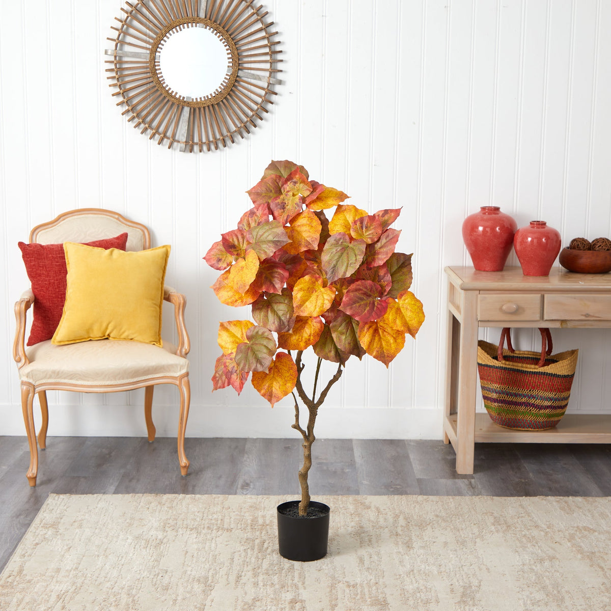 a tree in a room with a chair and a mirror