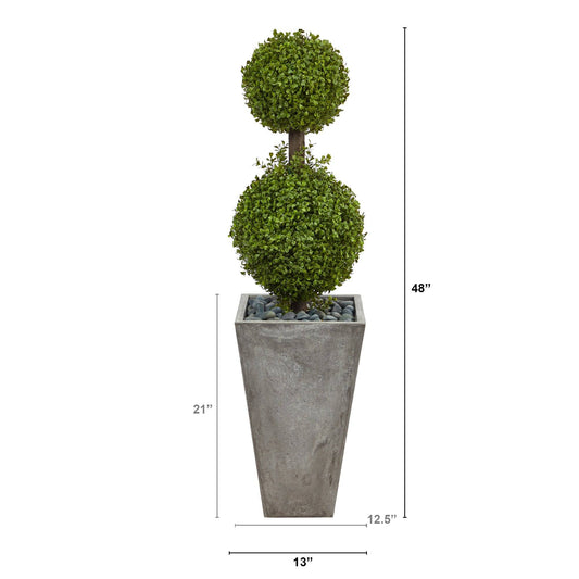 a tall planter with a tall plant in it