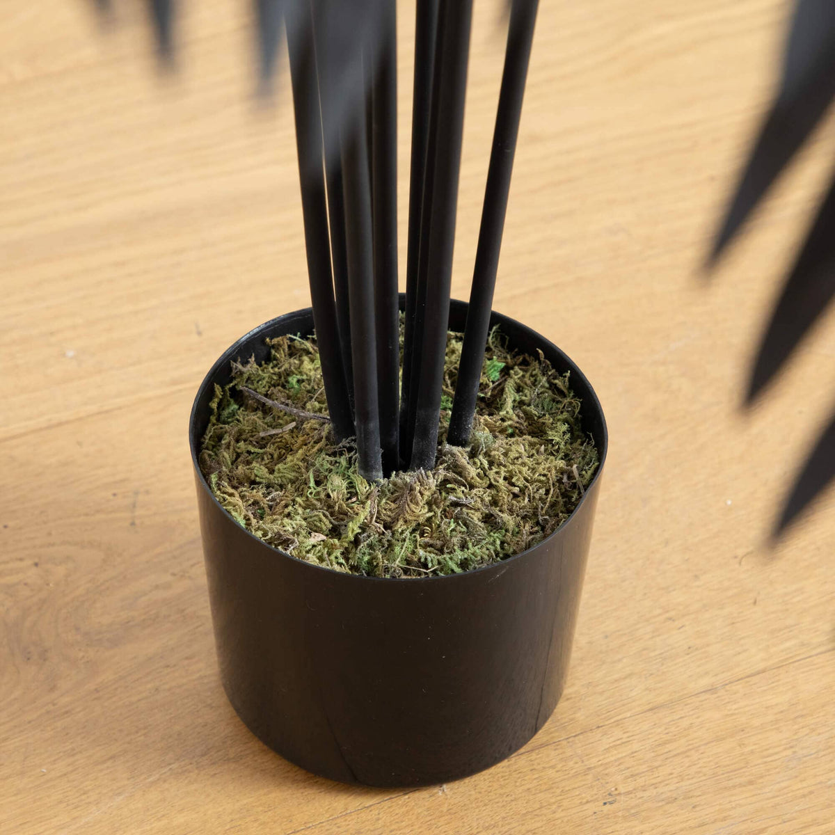 a black planter with black sticks in it