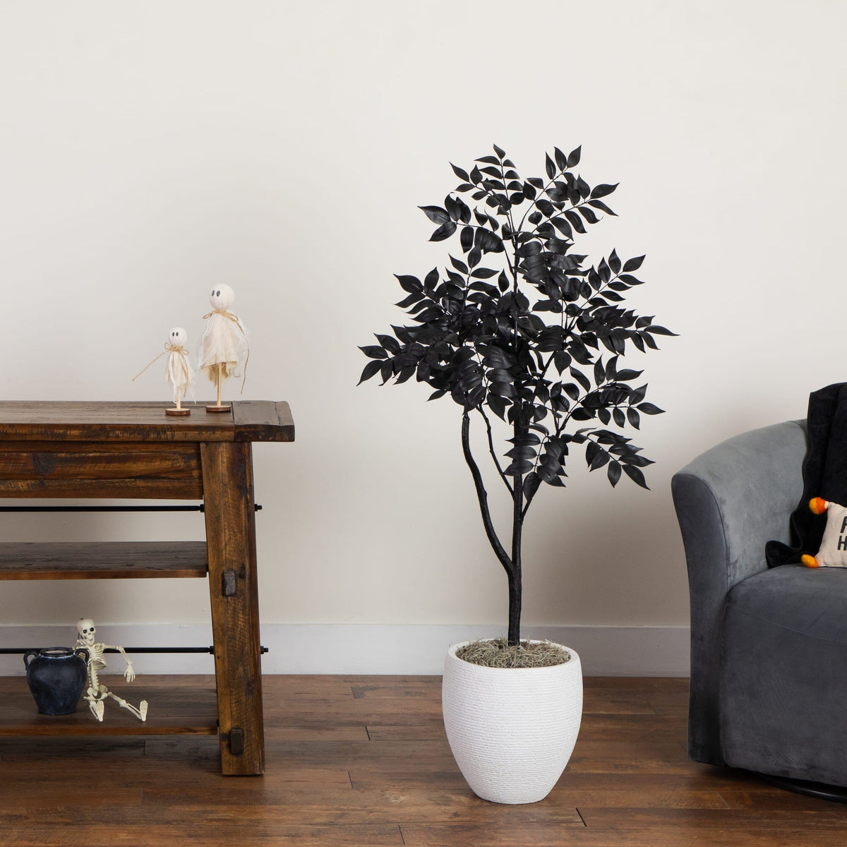 a plant in a white pot next to a wooden table