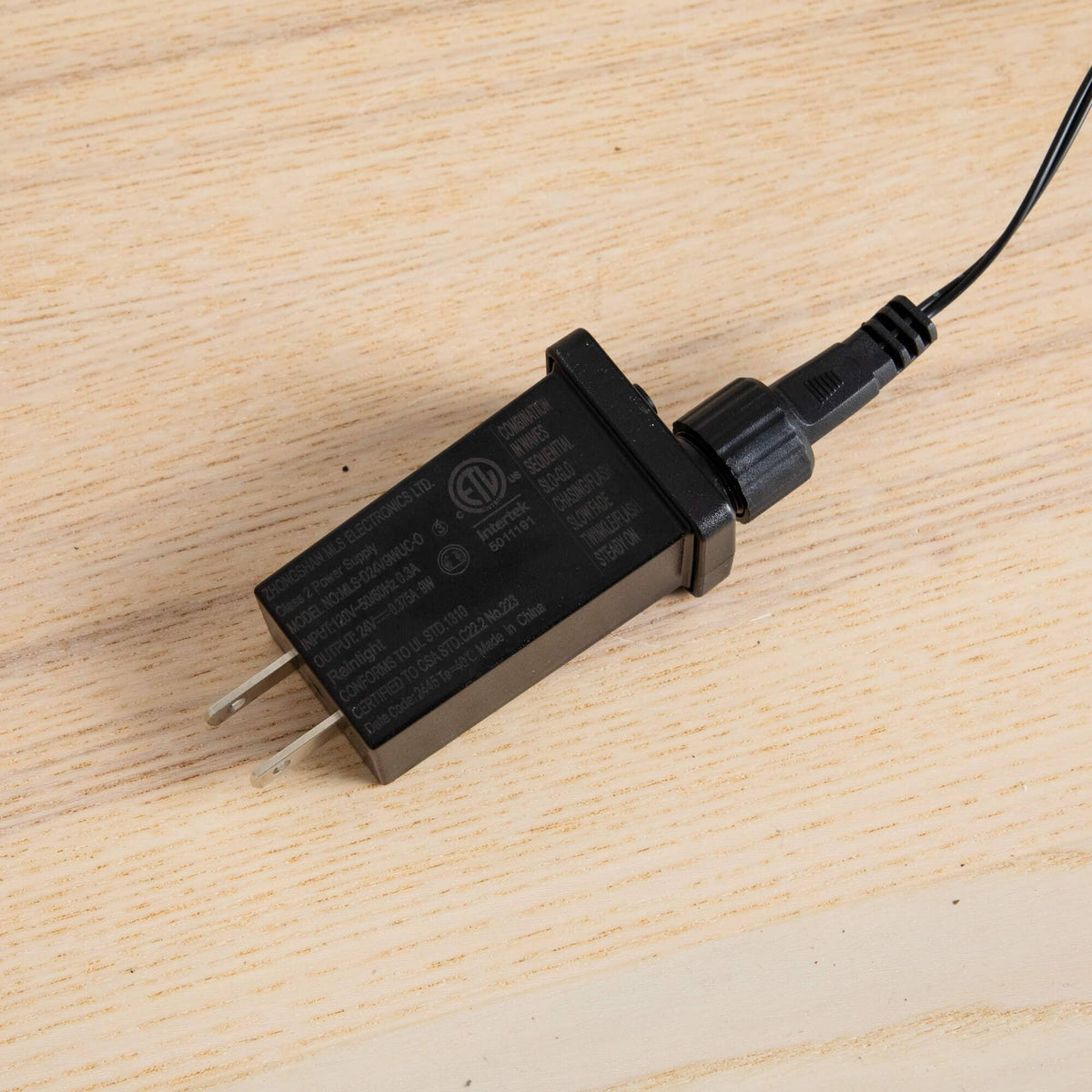 a black charger plugged into a cord