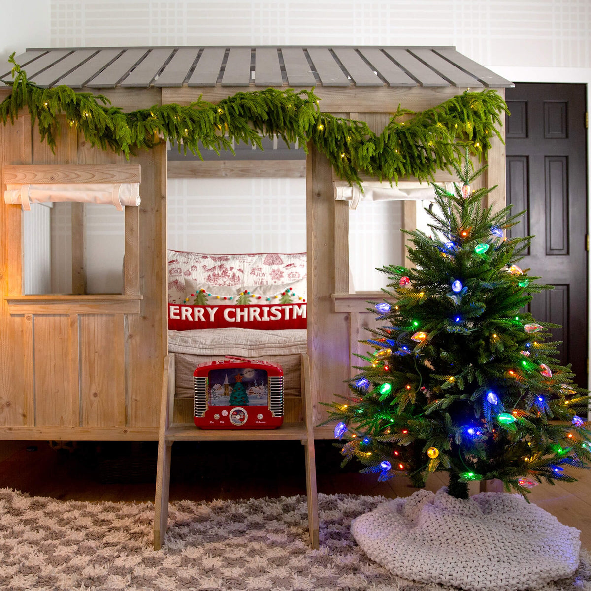 a tree with lights and a bed in a room
