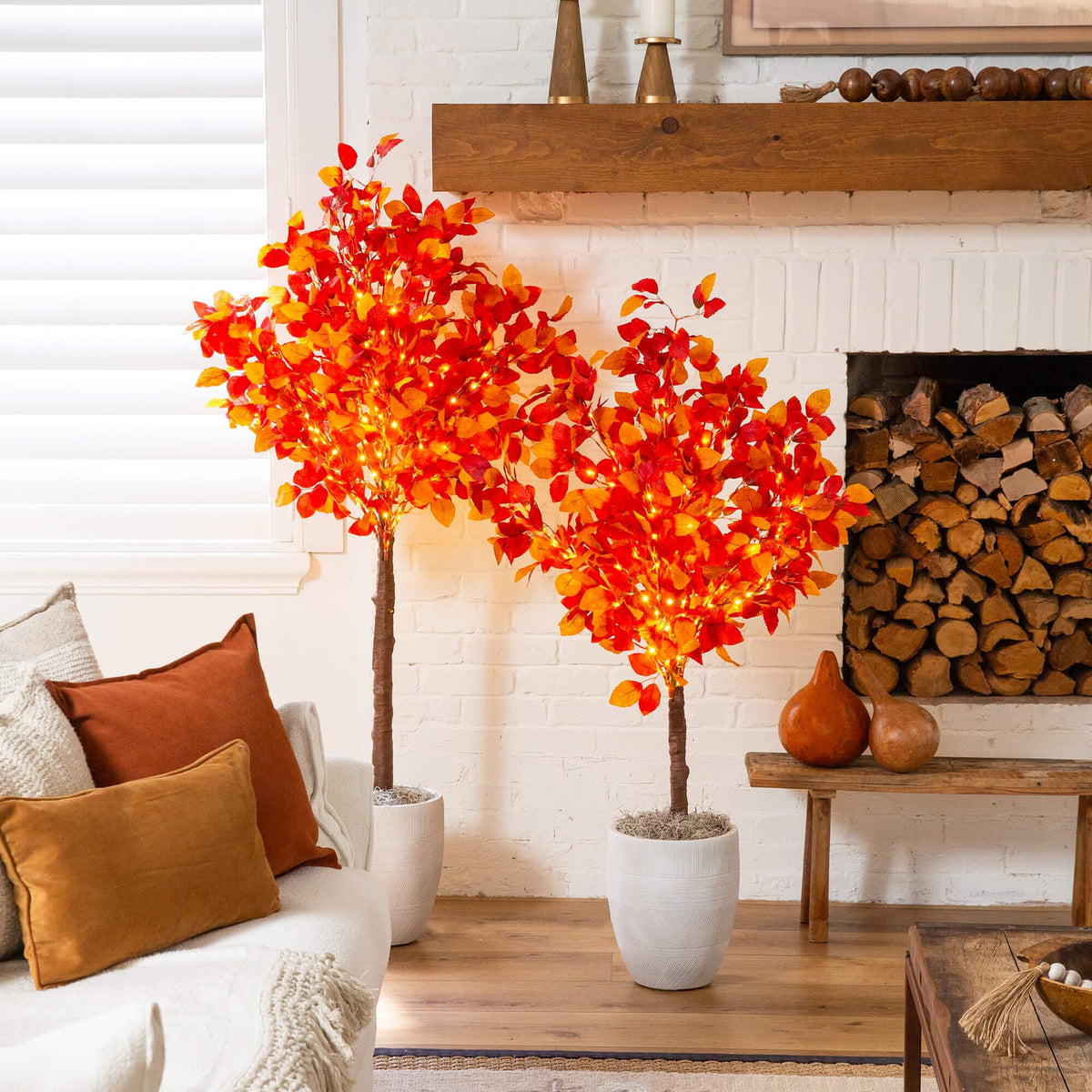 a couple trees in a room with a fireplace