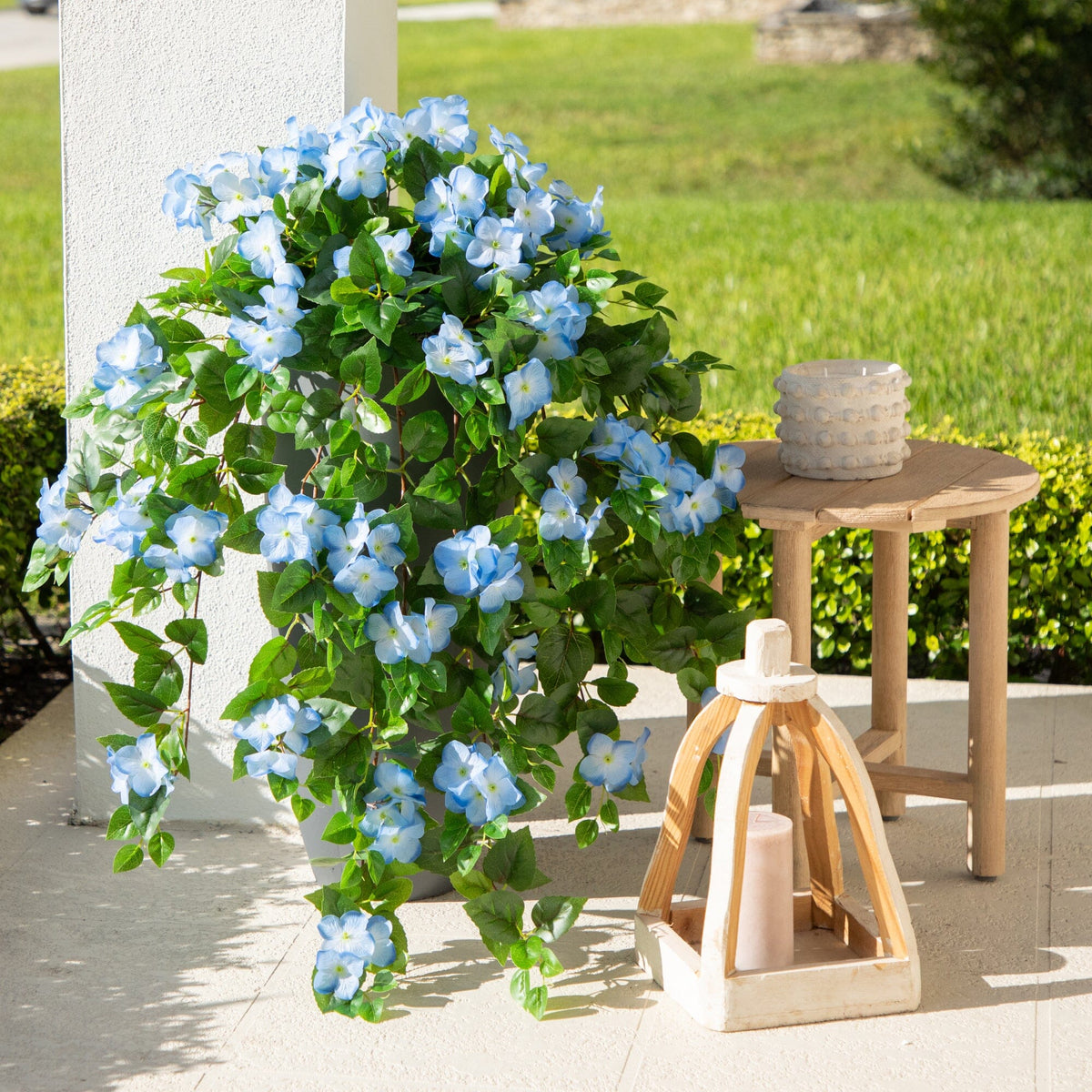 a plant with blue flowers and a candle on a table