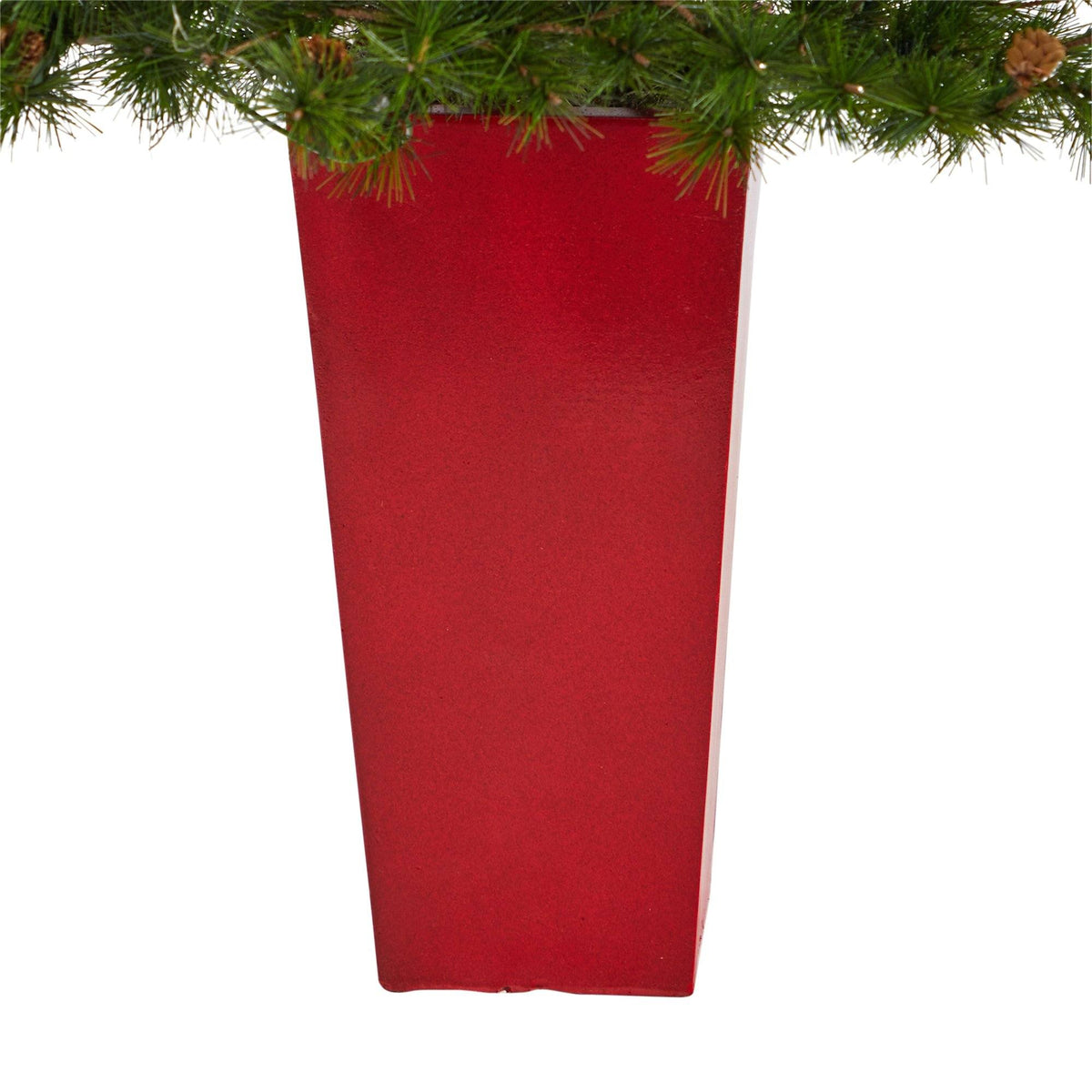 a red rectangular vase with pine branches