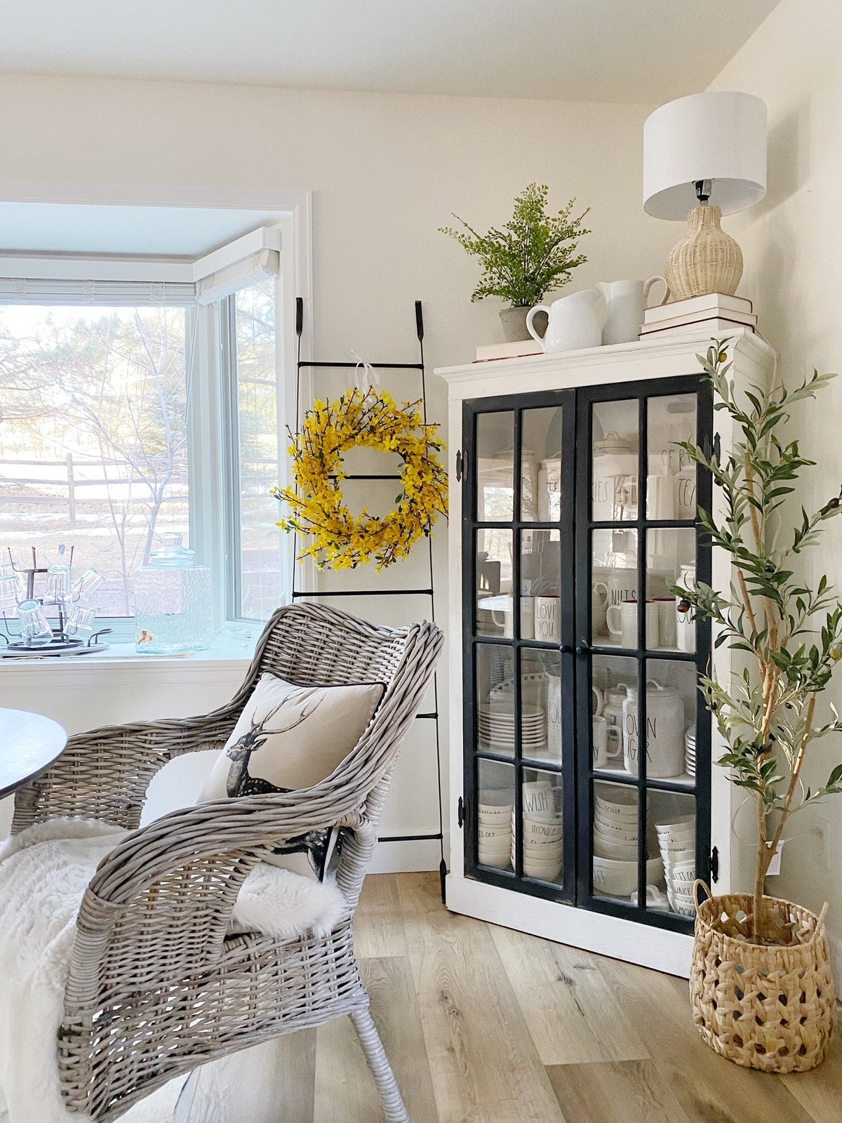 a wicker chair in a room with a glass cabinet and a window