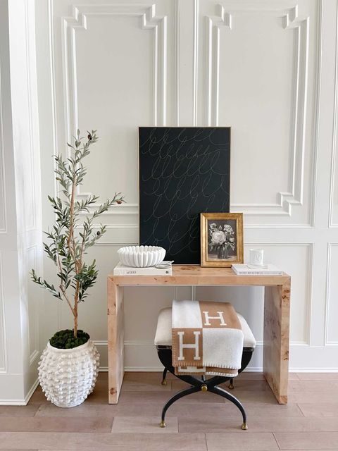 a table with a plant and a picture frame