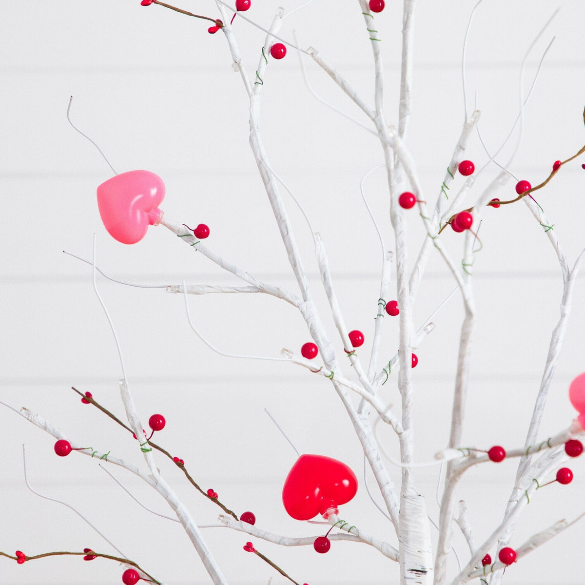 a tree with red berries and hearts