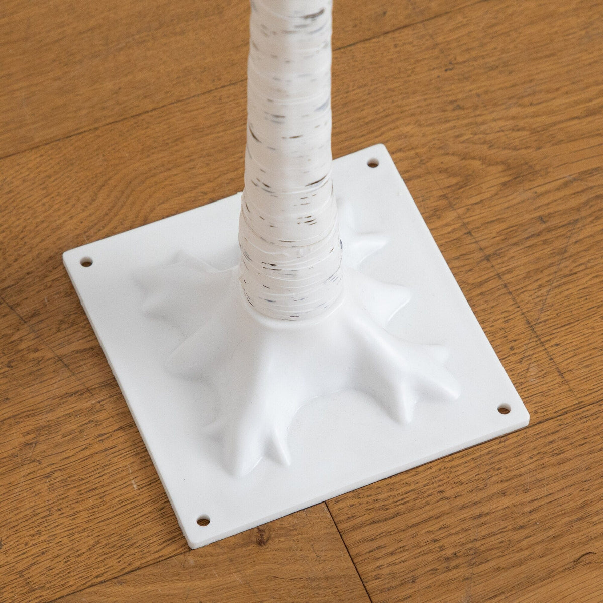 a white tree trunk on a wood floor