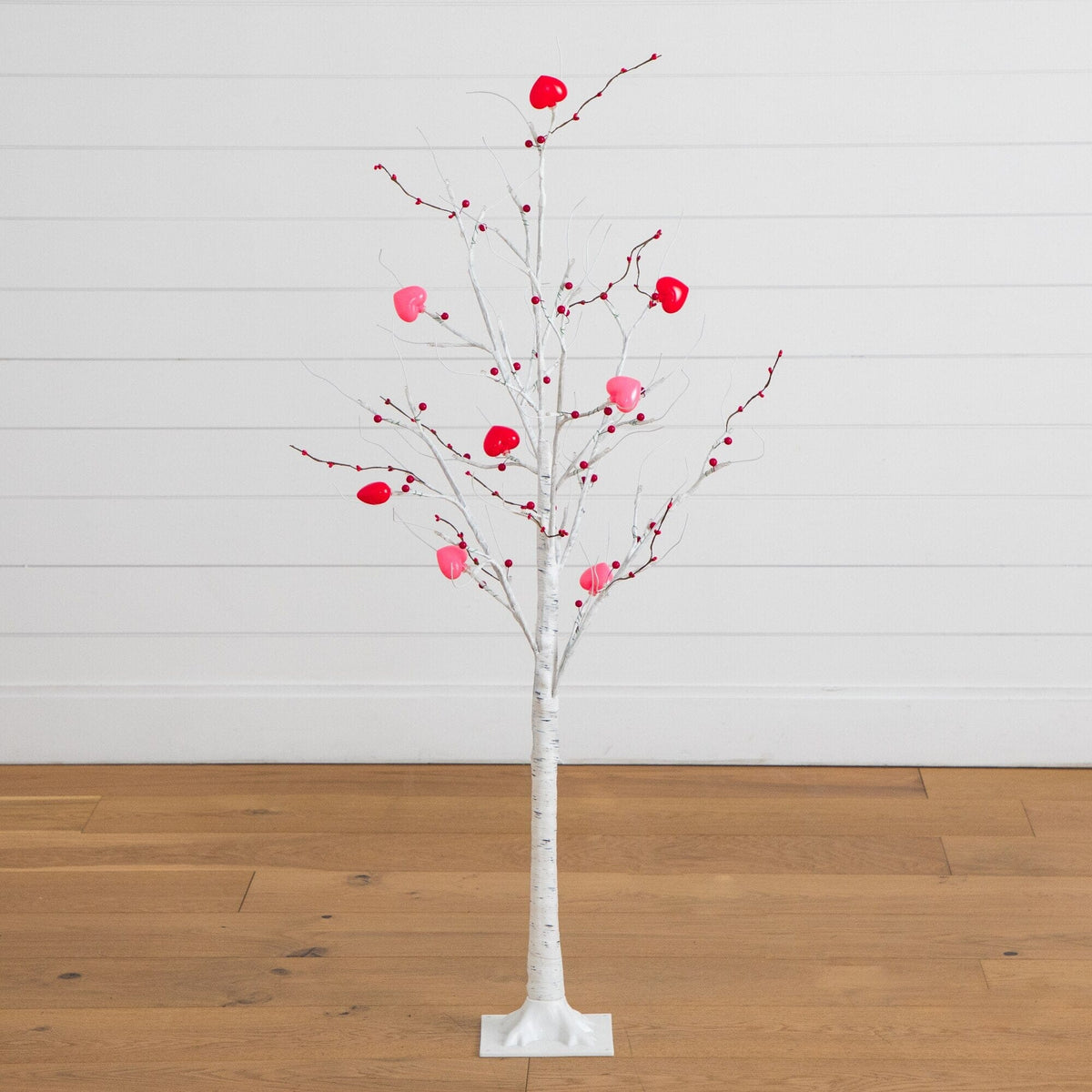 a white tree with pink berries on it