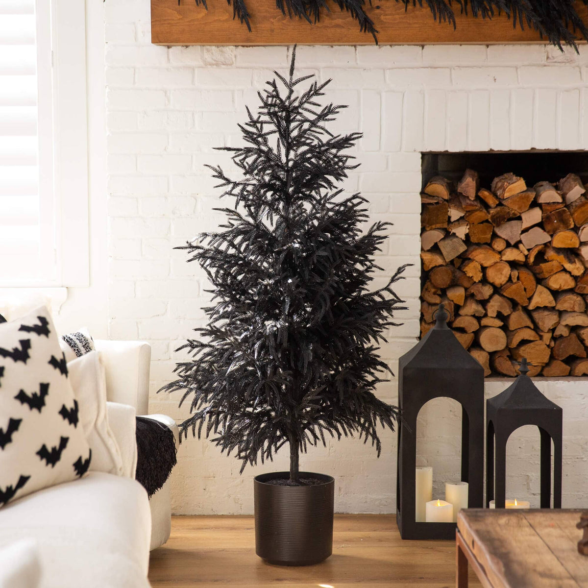 a tree in a pot in front of a fireplace