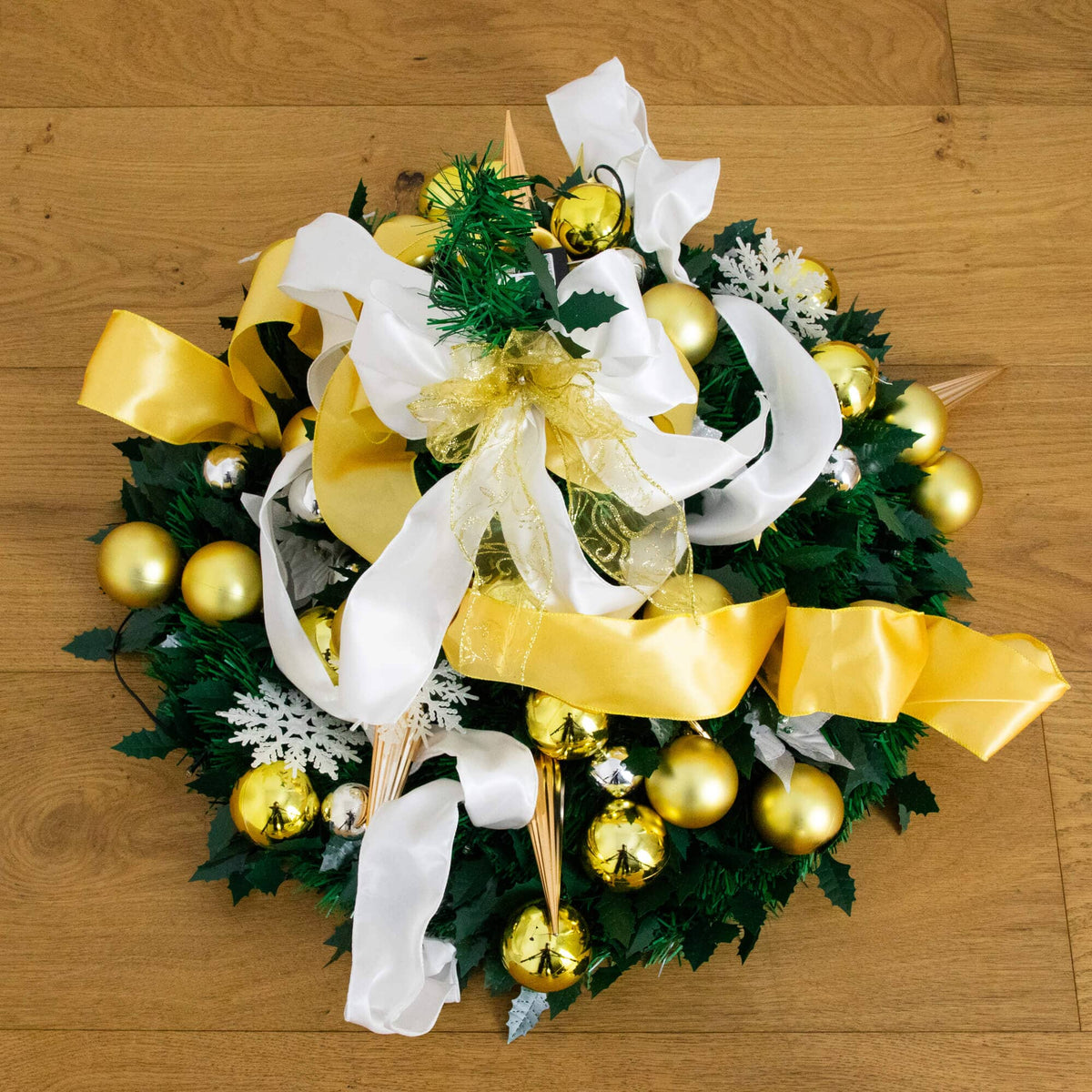 a wreath with gold ornaments and ribbons