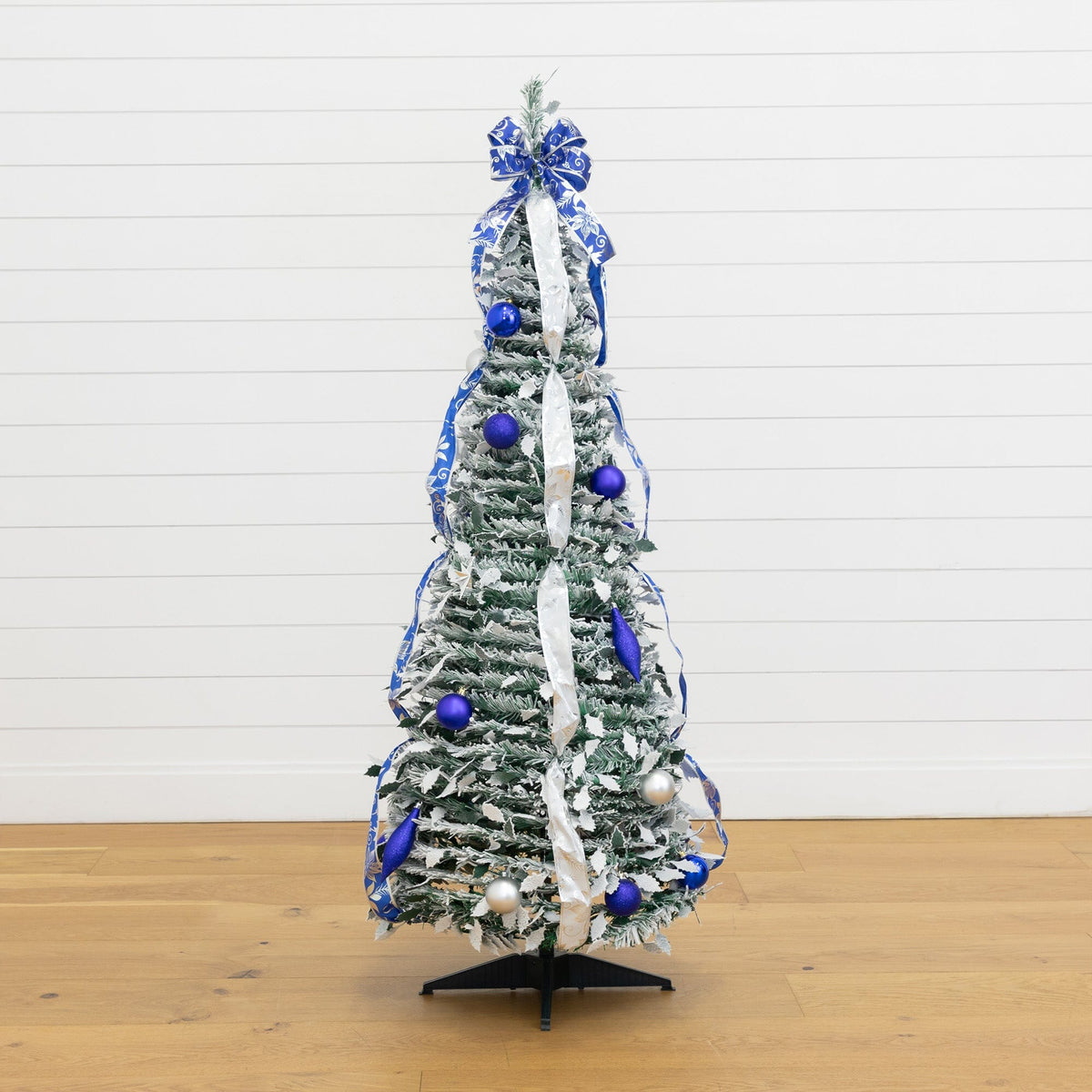 a small christmas tree with blue and silver decorations