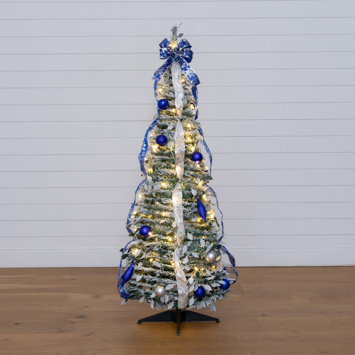 a small christmas tree with blue and silver decorations