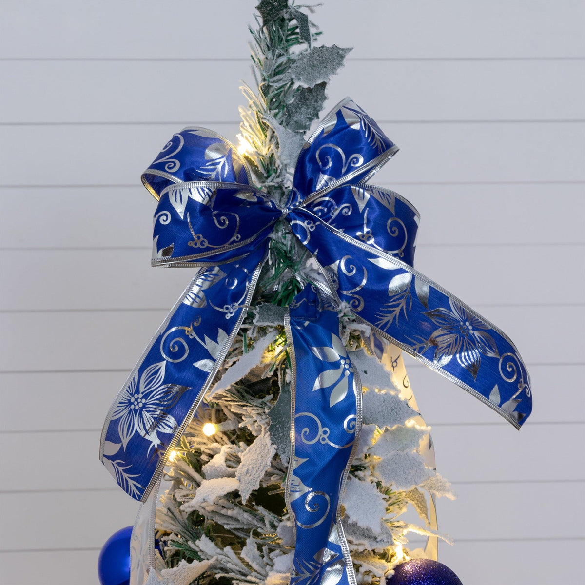 a small christmas tree with a blue bow