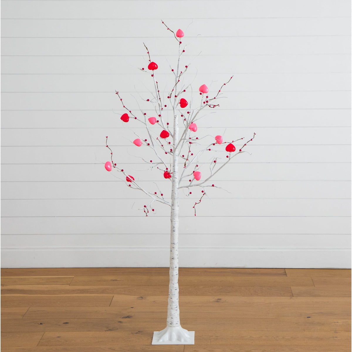 a white tree with pink balls on it