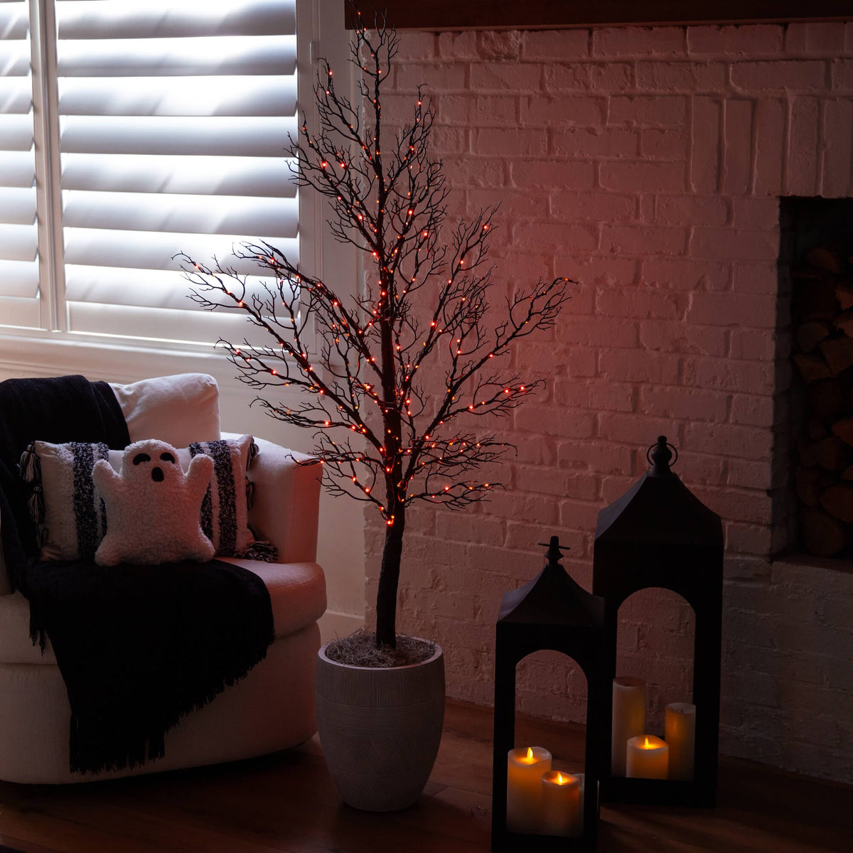 a tree in a room with a fireplace and a white chair