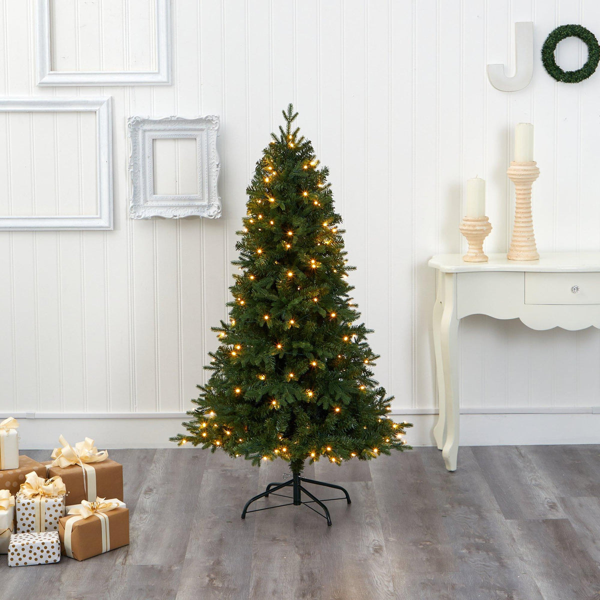 a christmas tree with lights and presents in a room