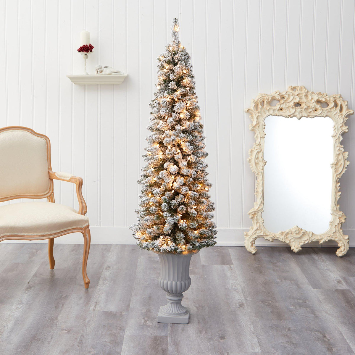 a christmas tree in a vase next to a mirror