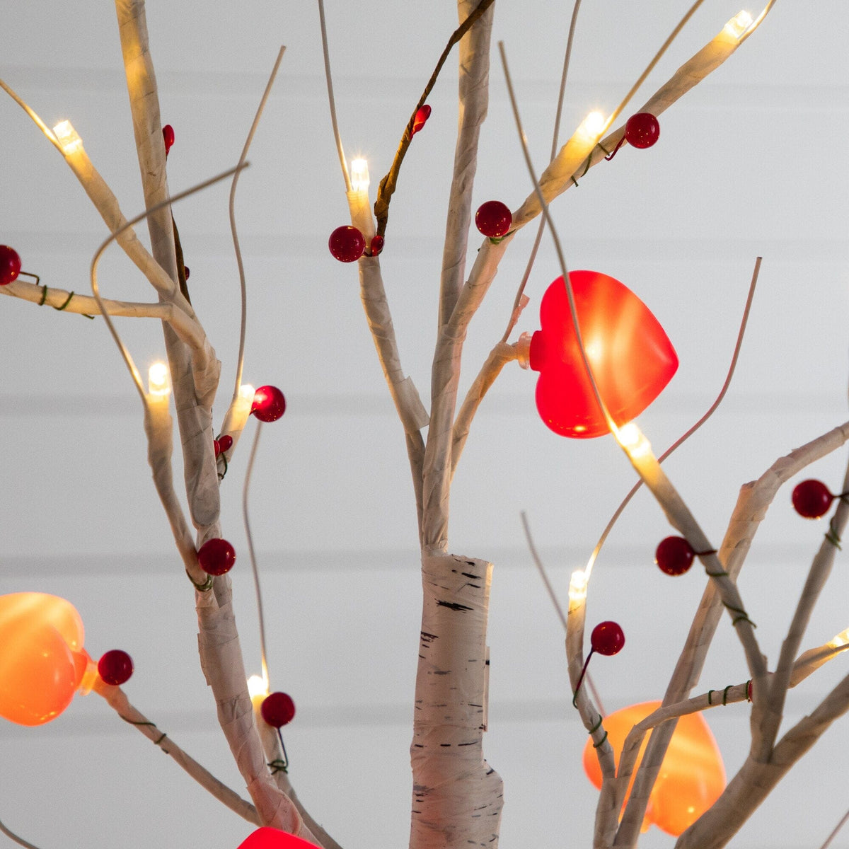 a tree with lights and red hearts