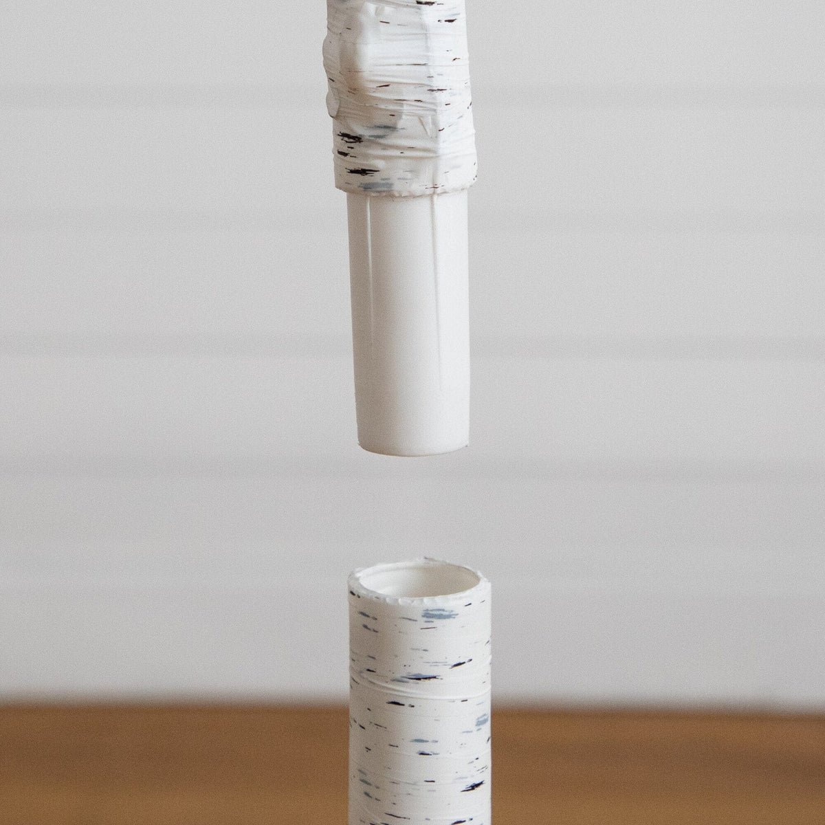 a white tube with a black and white speckled tube