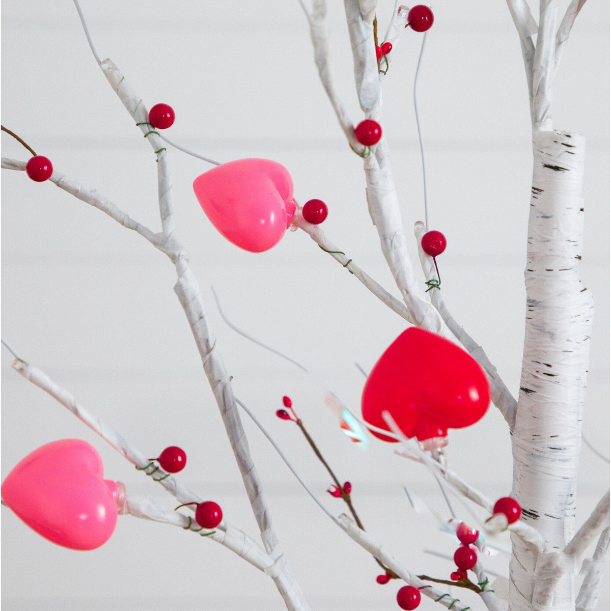 a tree with red berries and hearts