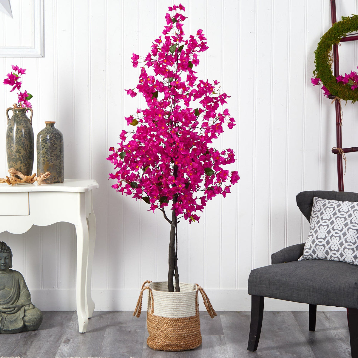 a pink flower in a pot next to a chair
