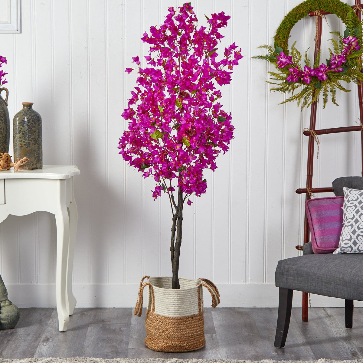 a purple flower in a pot next to a chair