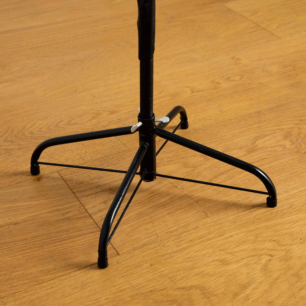 a black metal stand on a wood floor