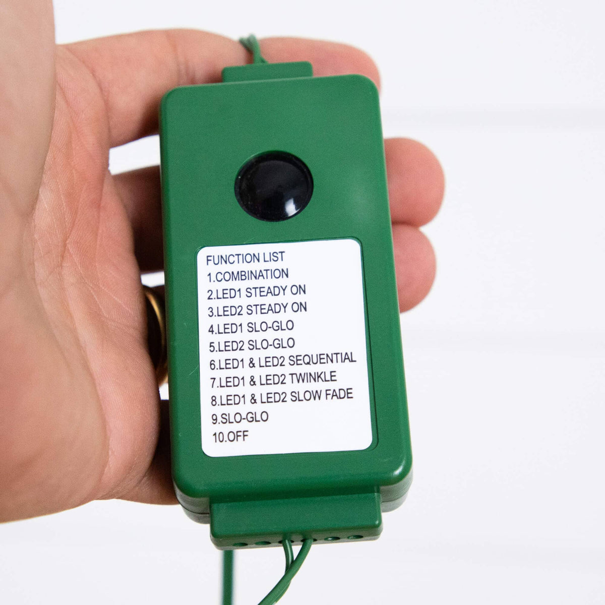 a hand holding a green device