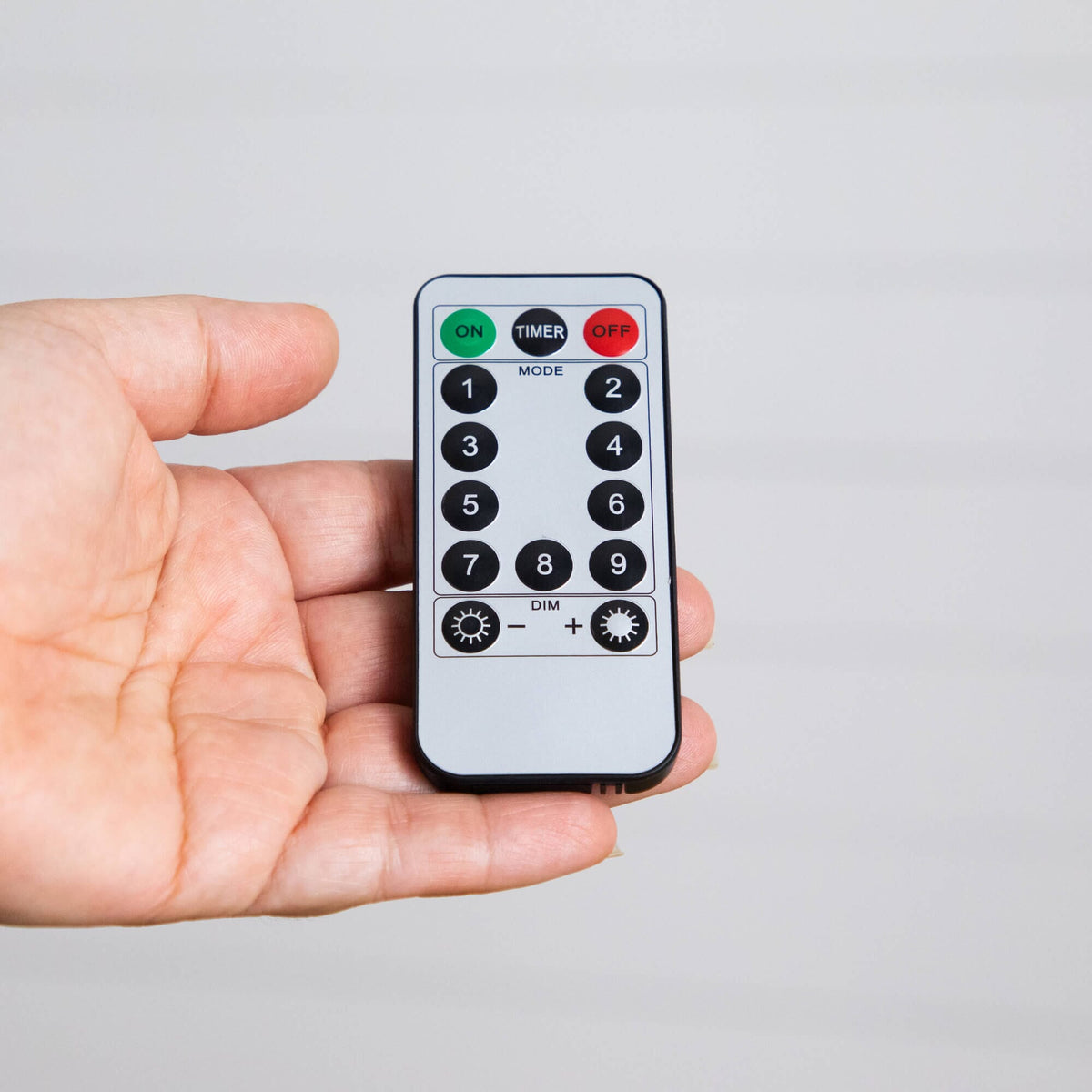 a hand holding a remote control