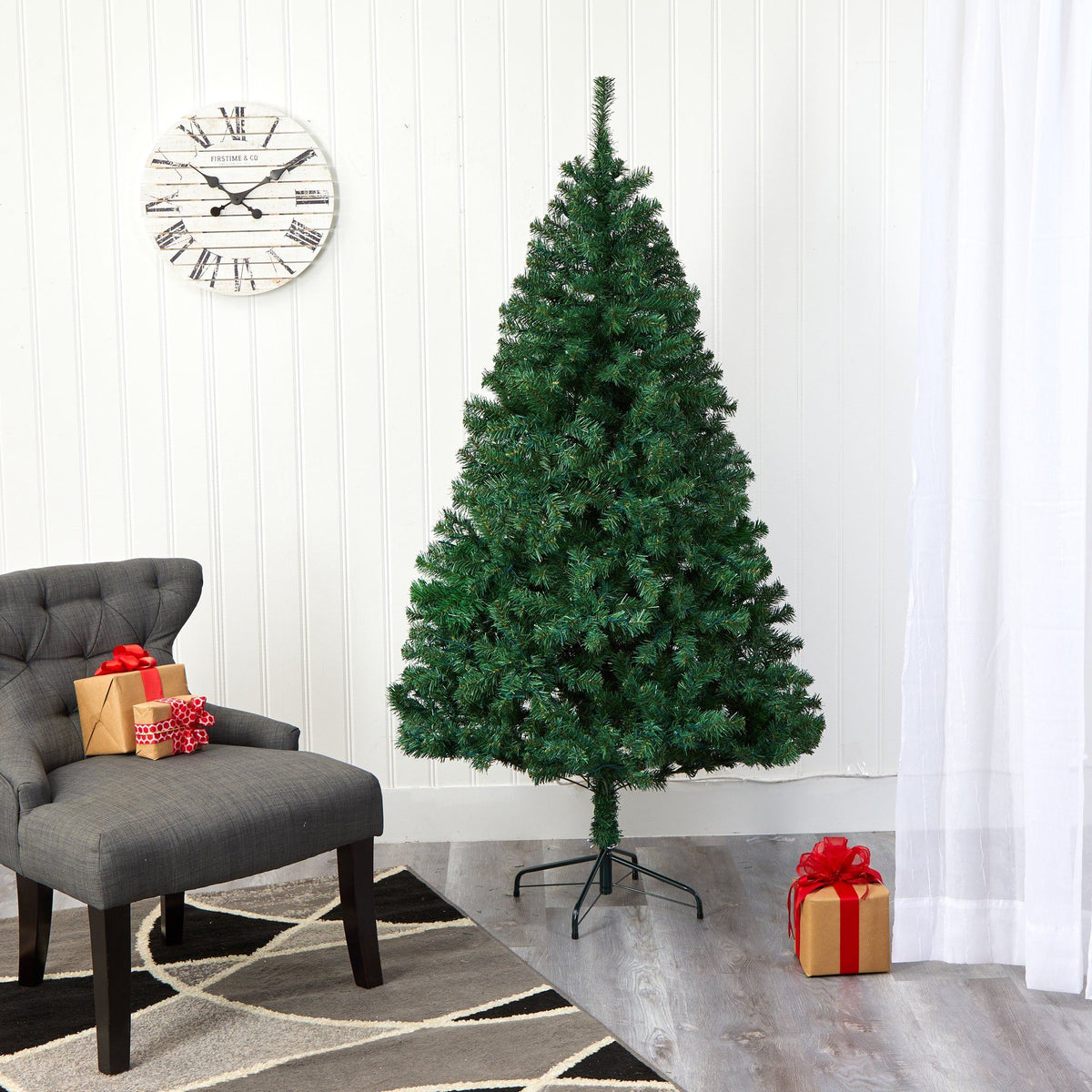 a christmas tree in a room with a chair and a clock