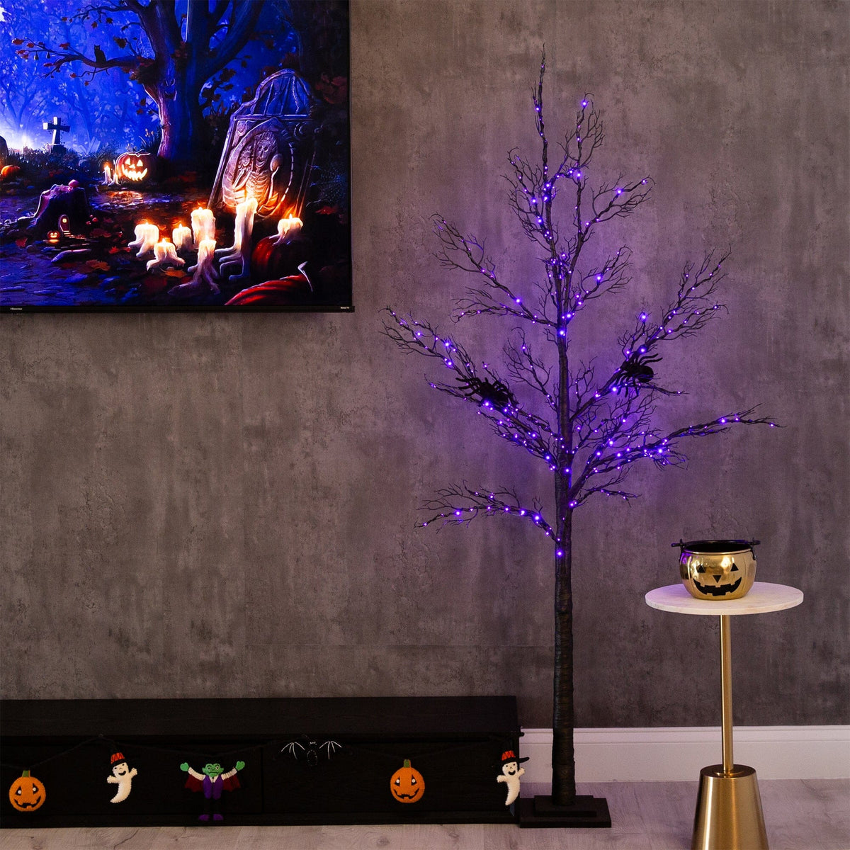 a tree with purple lights and a painting on the wall