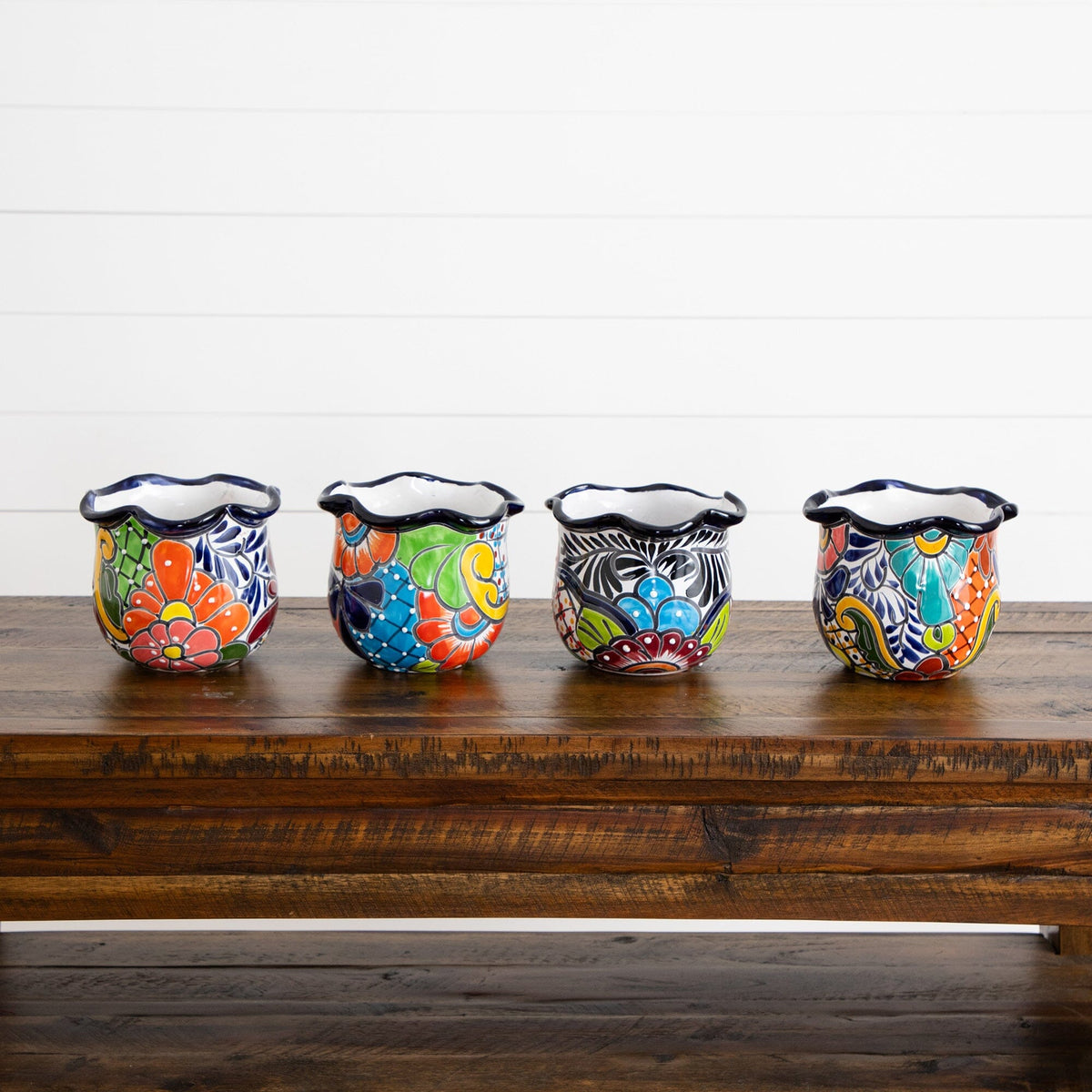 a group of colorful vases on a wooden table