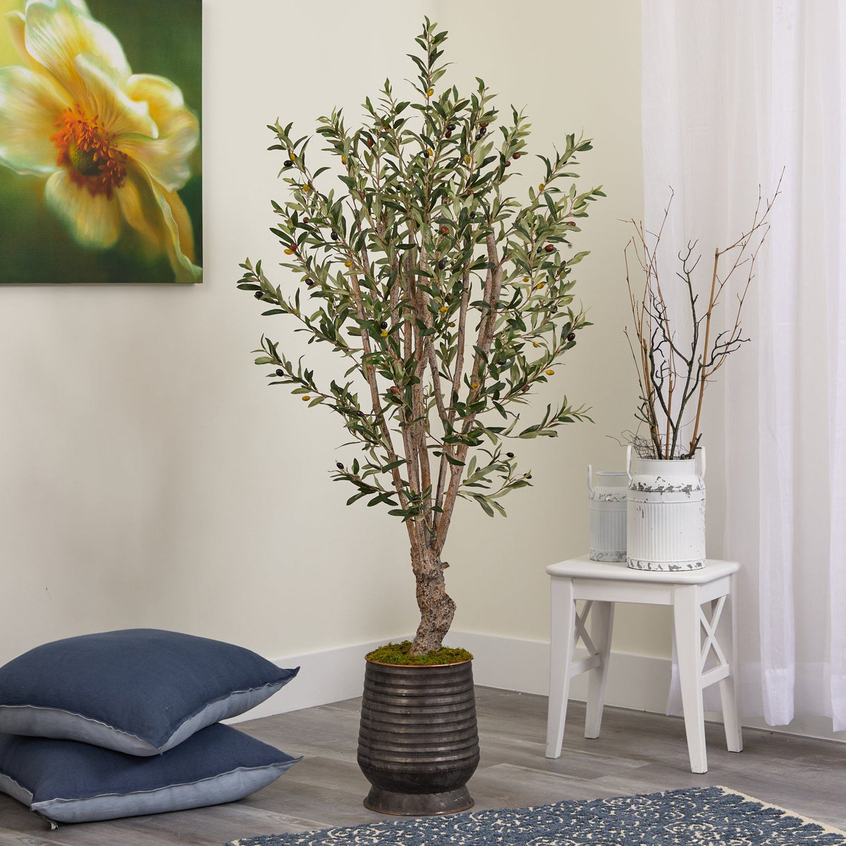 a plant in a pot next to pillows and a painting