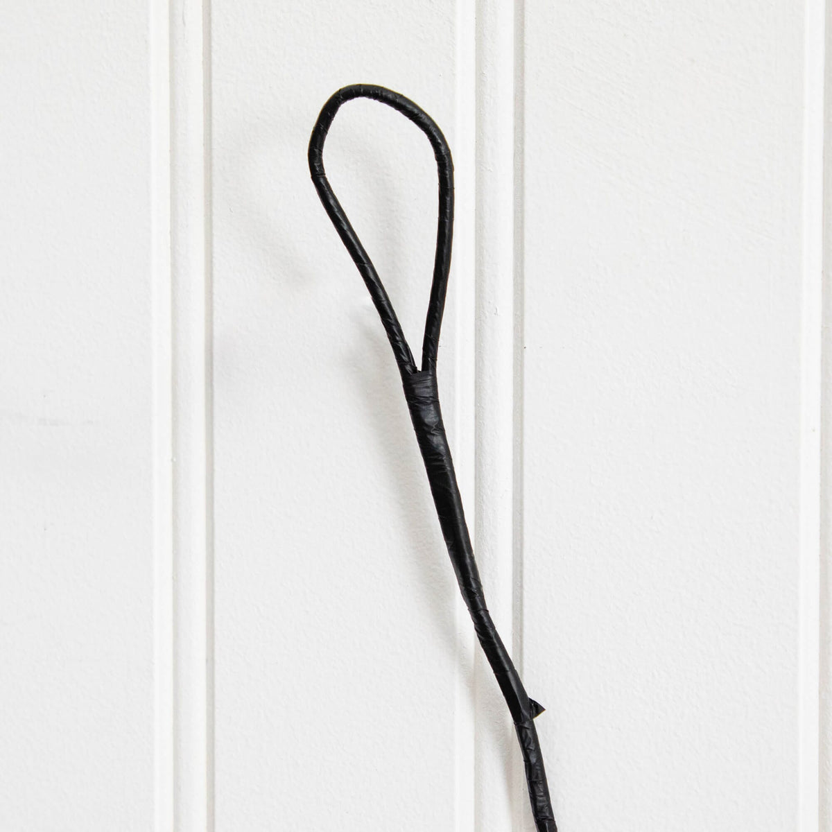 a black rope on a white wall