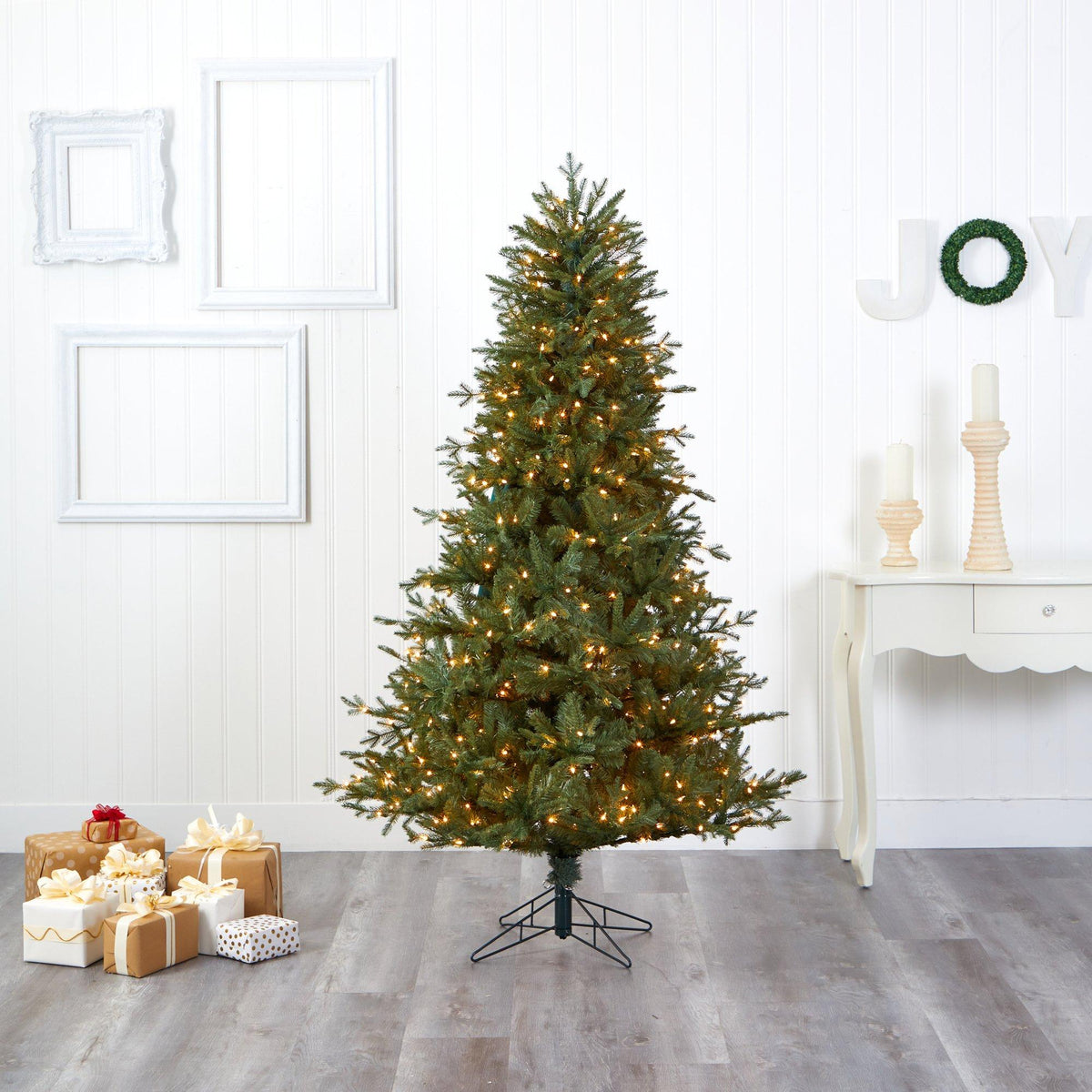a christmas tree with lights and presents in a room