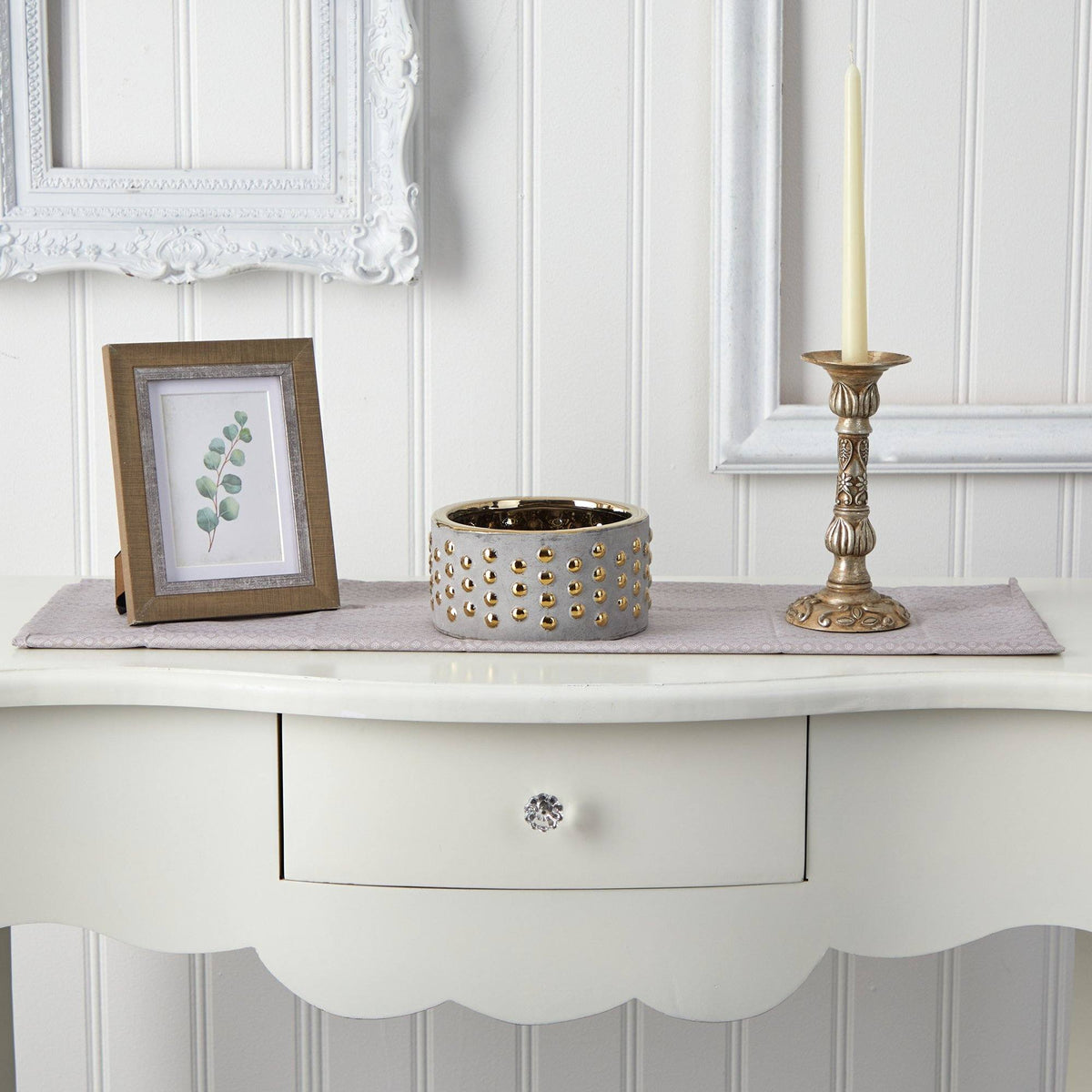 a white table with a candle and a picture frame