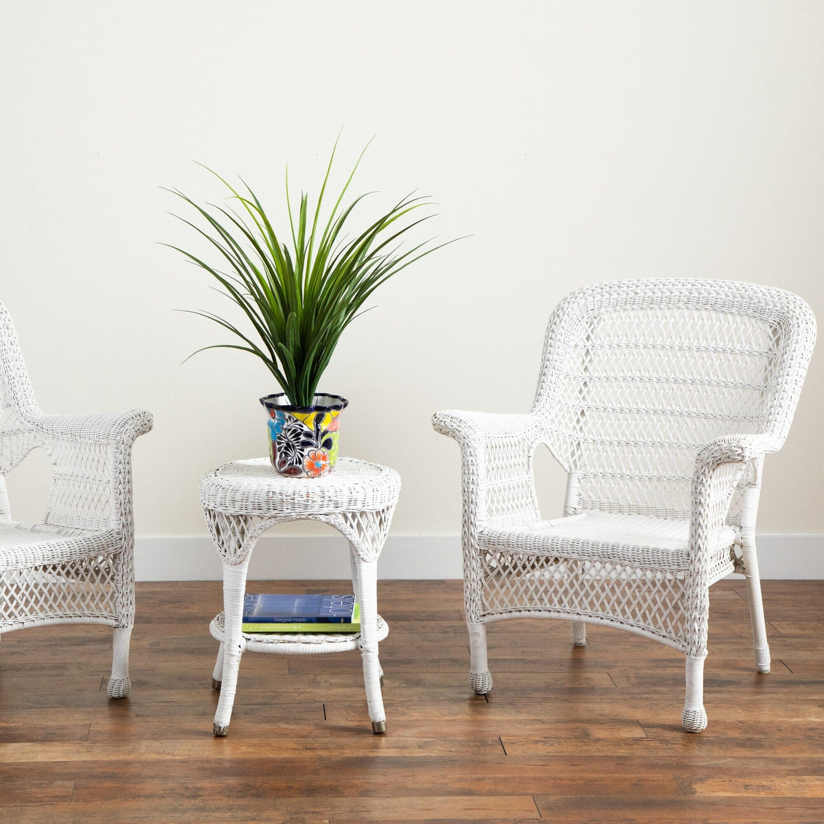 a white wicker chairs and a plant on a table