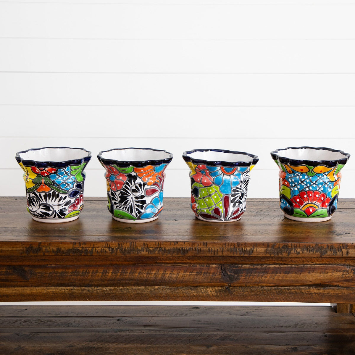 a row of colorful cups on a wooden table