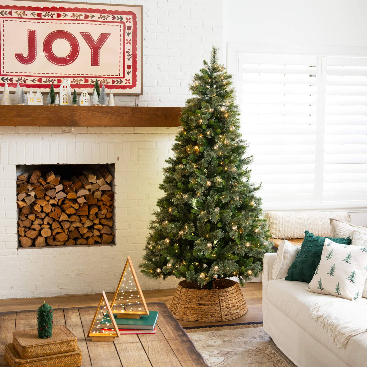 a christmas tree in a basket in front of a fireplace