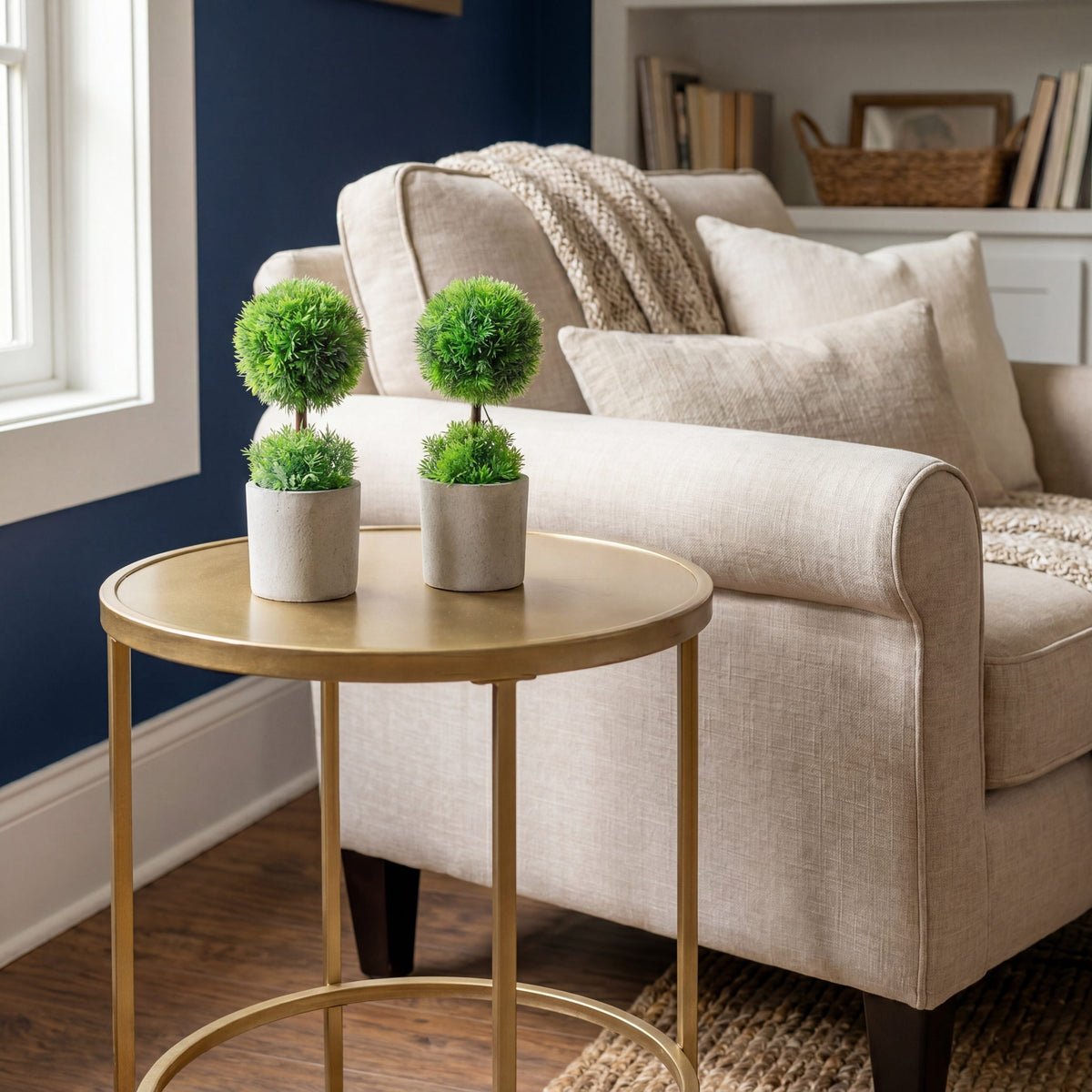 a small round table with plants on it in front of a couch