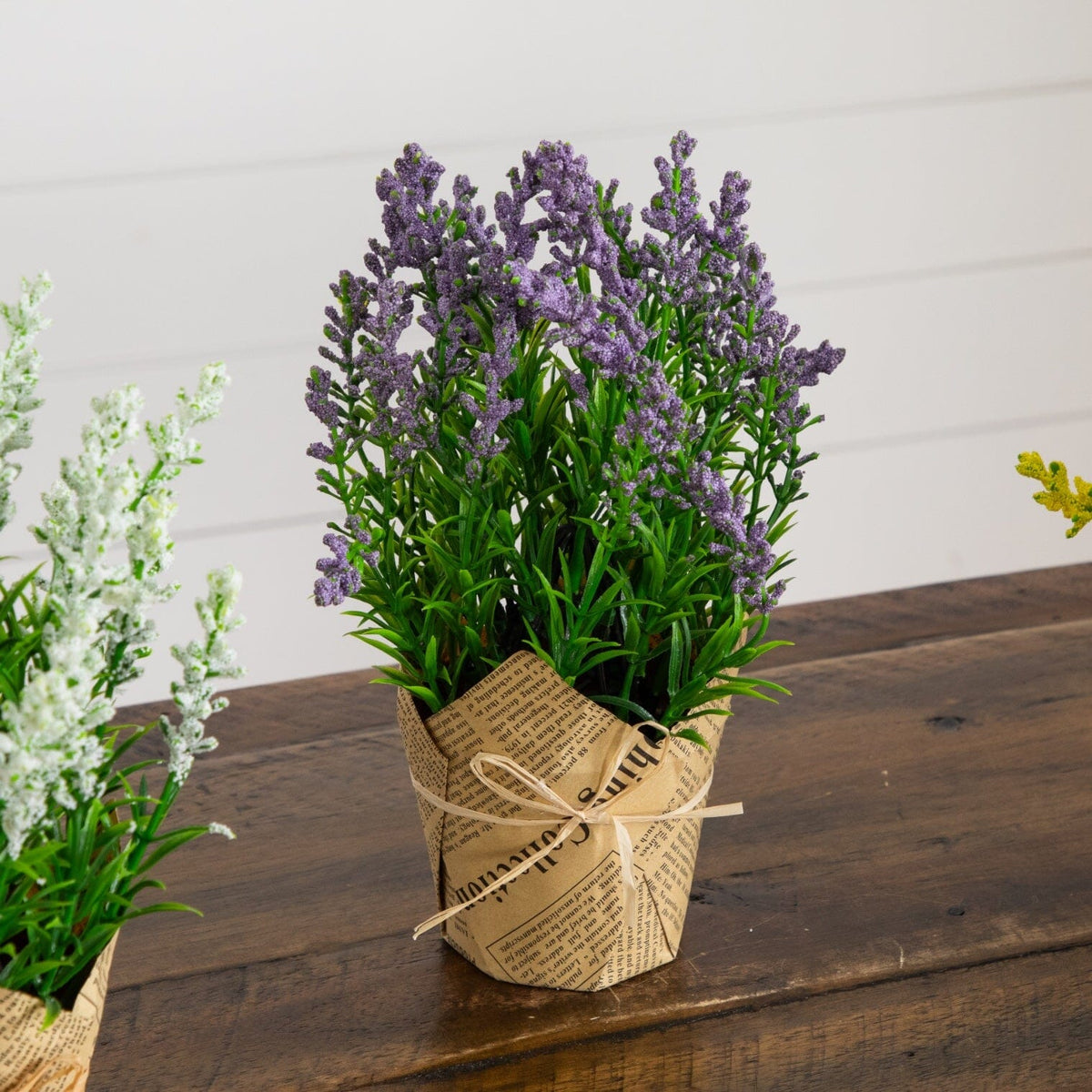 a group of fake flowers in a paper pot