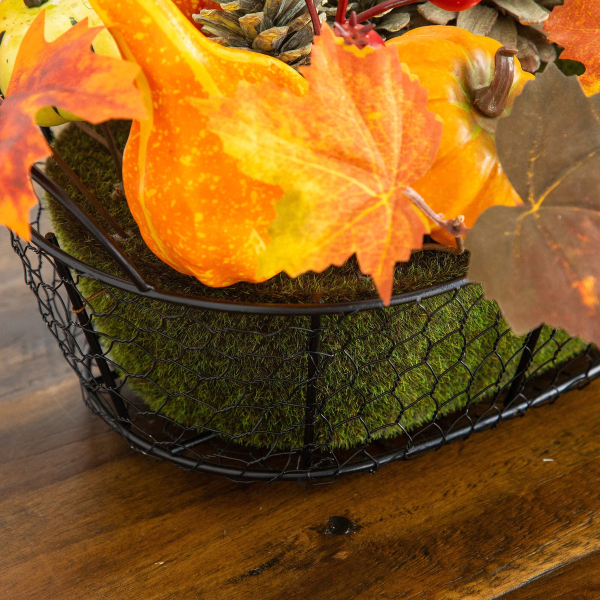 a basket of fake leaves and pumpkins