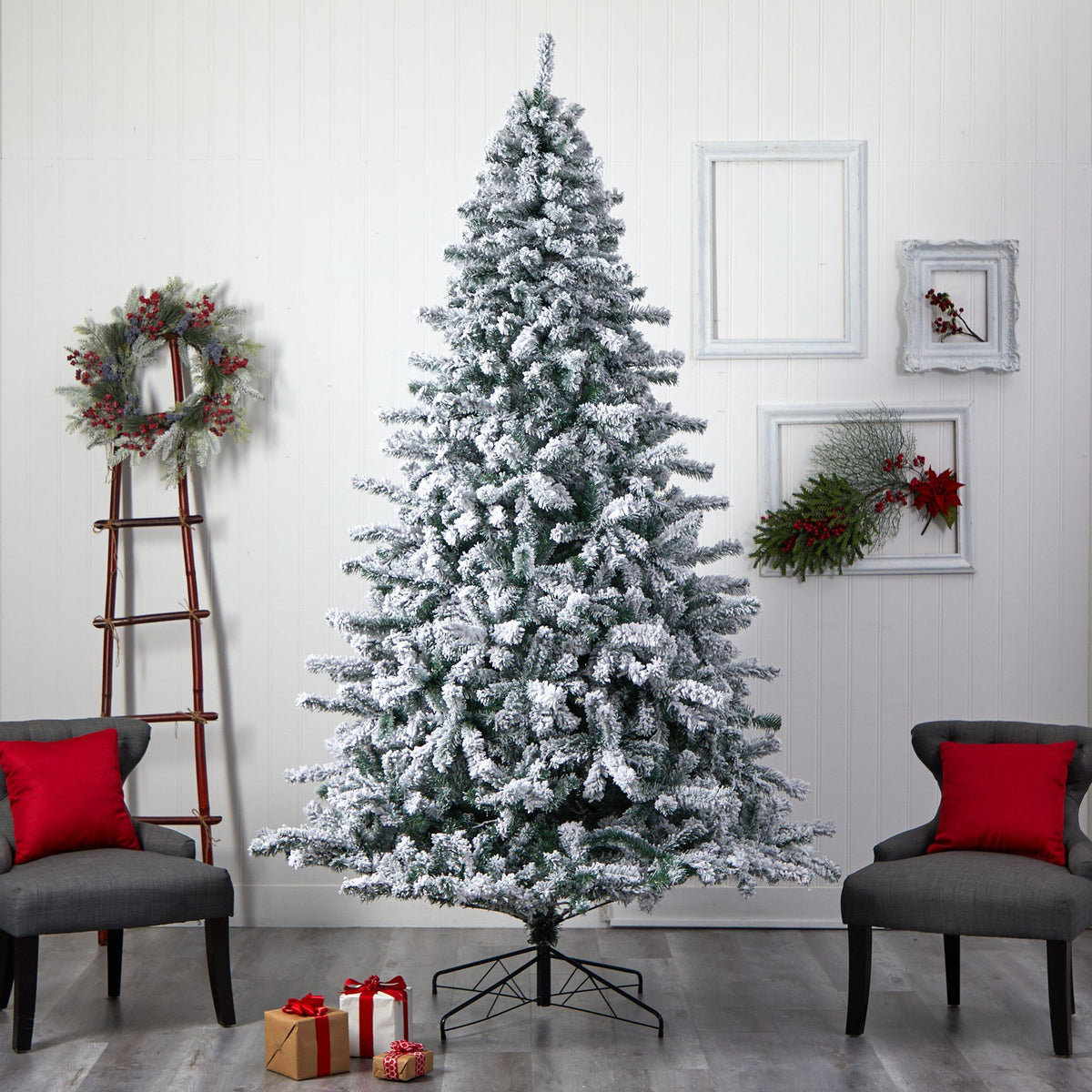 a christmas tree in a room with chairs and a wreath