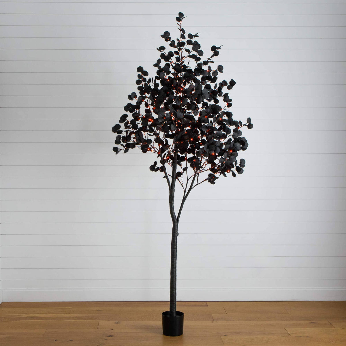 a tree with red lights in a pot