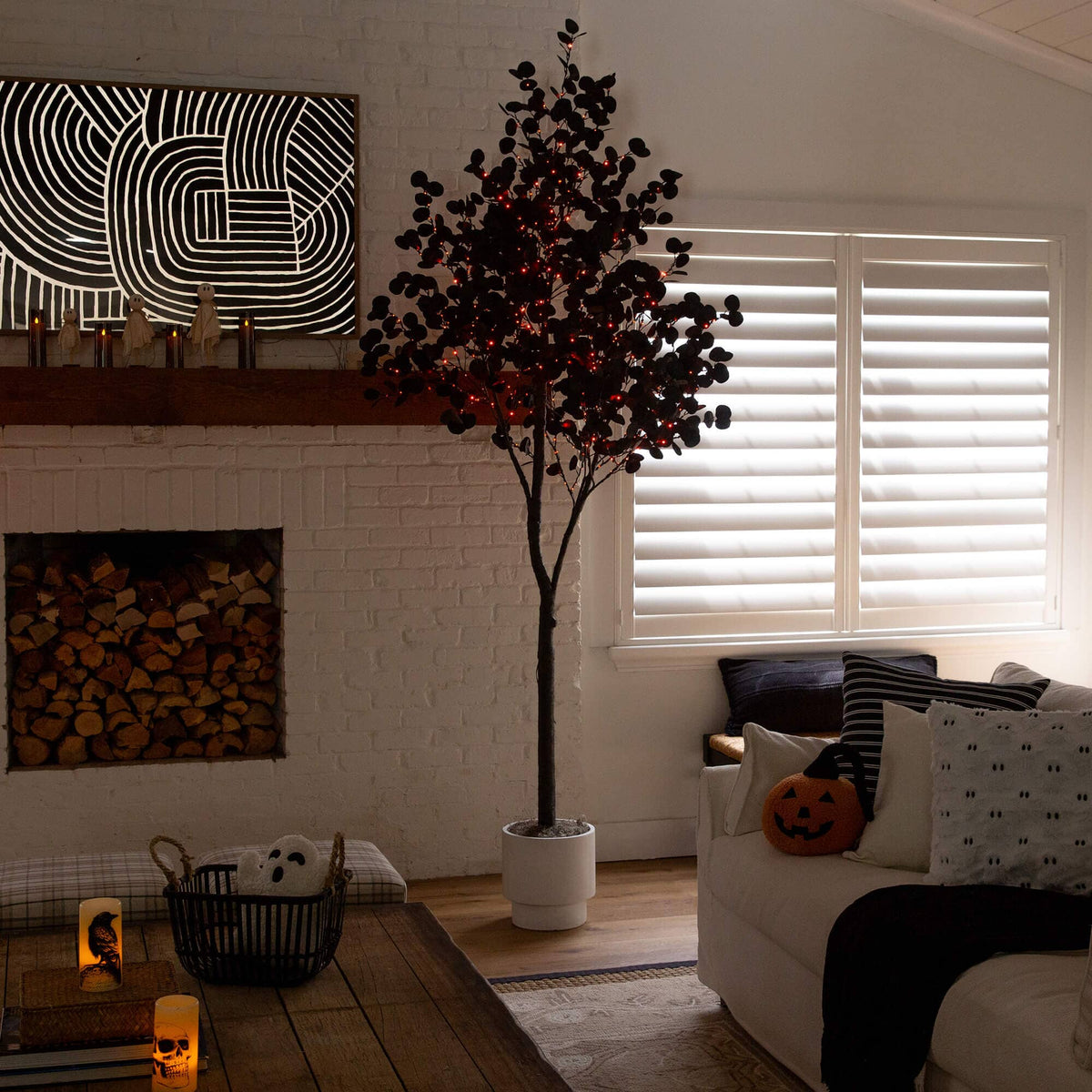 a living room with a tree and a painting on the wall