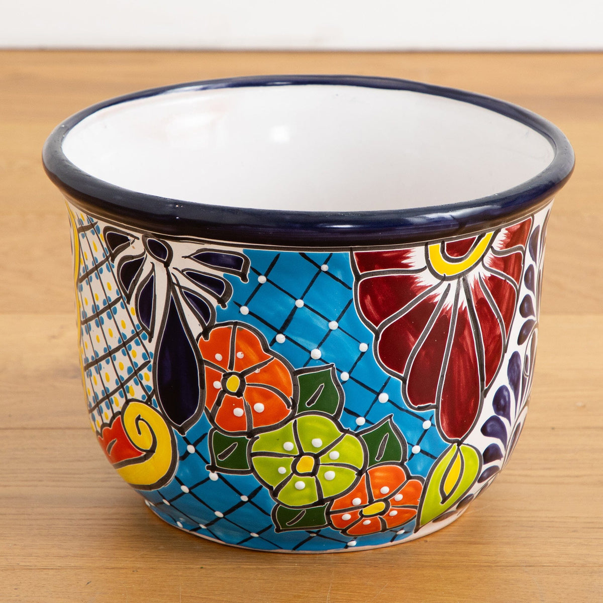 a colorful painted bowl on a wood surface